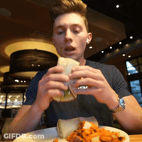 A Man Eating A Sandwich With A Shirt That Says Abercrombie GIF
