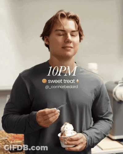 A Man Eating An Ice Cream Cone With A 10Pm Sweet Treat Advertisement Behind Him GIF