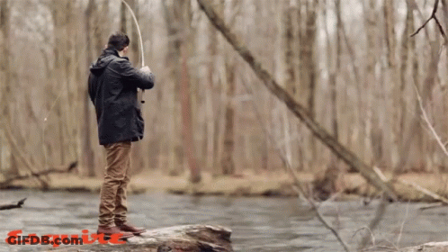 A Man Fishing In A River With The Word Esquire On The Bottom Right GIF