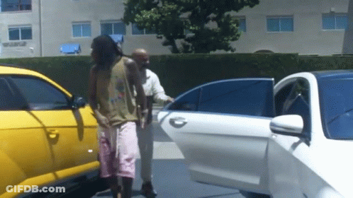 A Man Getting Out Of A White Car With A Yellow Car Behind Him GIF