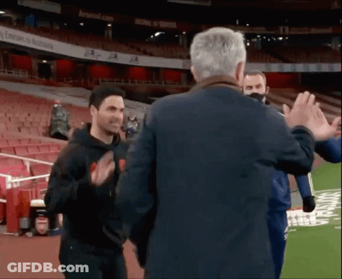 A Man Giving A High Five To Another Man In A Stadium GIF