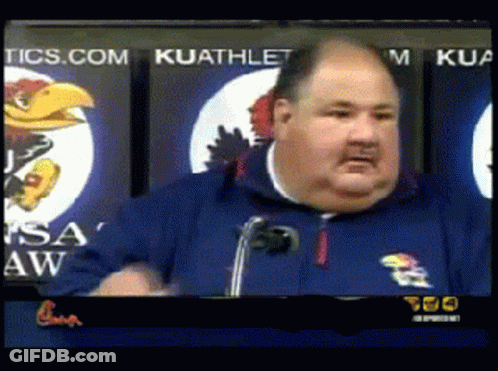 A Man Giving A Speech In Front Of A Kuathletic Sign GIF