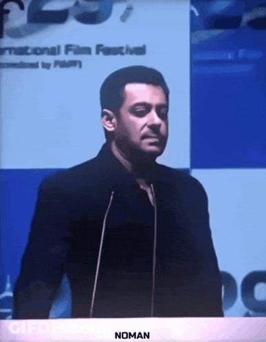 A Man Giving A Speech In Front Of A Sign That Says International Film Festival GIF