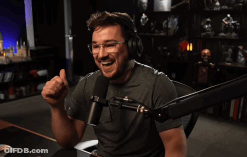 A Man Giving A Thumbs Up In Front Of A Microphone With The Words " Two Thumbs Up " Below Him GIF