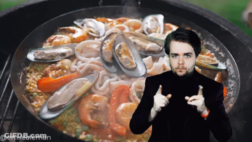 A Man Giving A Thumbs Up In Front Of A Pan Of Seafood And Rice GIF