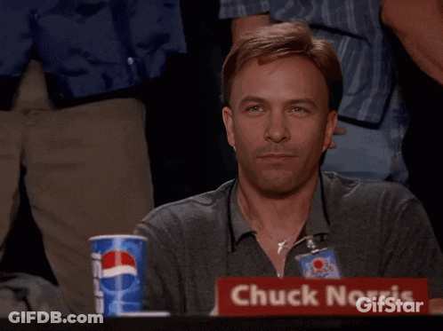 A Man Giving A Thumbs Up In Front Of A Sign For Chuck Norris GIF