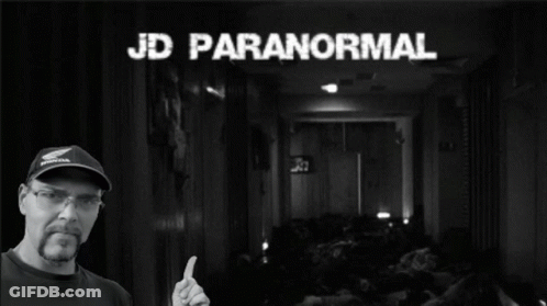 A Man Giving A Thumbs Up In Front Of A Sign That Says Paranormal GIF