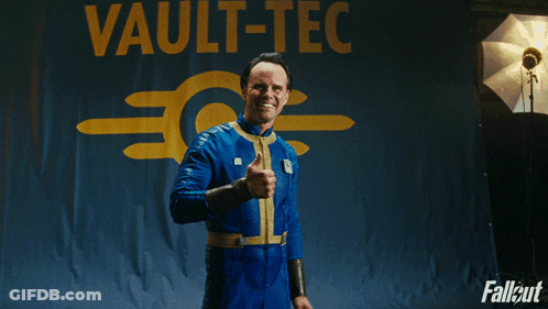 A Man Giving A Thumbs Up In Front Of A Sign That Says Vault GIF