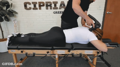 A Man Giving A Woman A Massage In Front Of A Sign That Says Cipria GIF