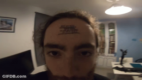 A Man Has A Tattoo On His Forehead That Says ' I Am A Fool ' GIF
