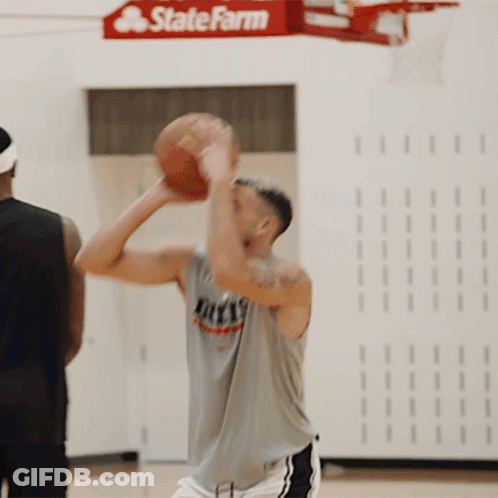 A Man Holding A Basketball In Front Of A Sign For State Farm GIF
