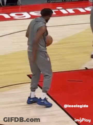 A Man Holding A Basketball On A Basketball Court With The Word Ing On The Floor GIF
