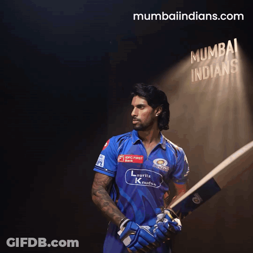 A Man Holding A Bat In Front Of A Sign That Says ' Mumbai Indians ' GIF