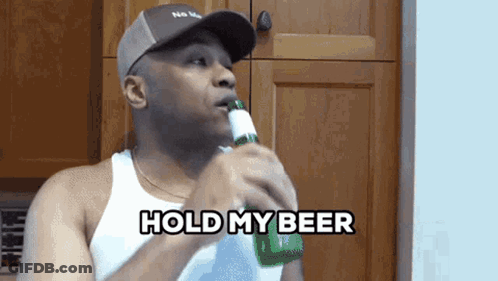 A Man Holding A Bottle Of Beer With The Words Hold My Beer Behind Him GIF