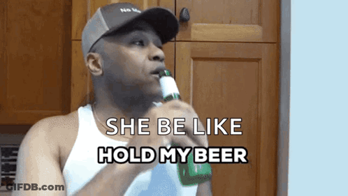 A Man Holding A Bottle Of Beer With The Words She Be Like Hold My Beer Below Him GIF