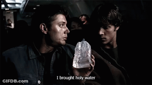 A Man Holding A Bottle That Says I Brought Holy Water On It GIF