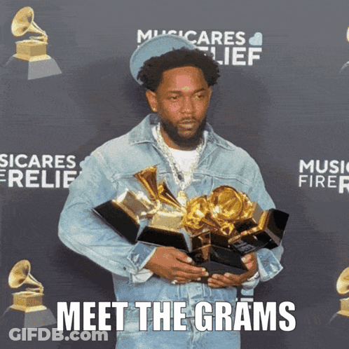 A Man Holding A Bunch Of Awards With The Words Meet The Grams Written Below Him GIF