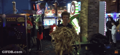 A Man Holding A Bunch Of Spaghetti In Front Of A Machine That Says Ticket Eater GIF
