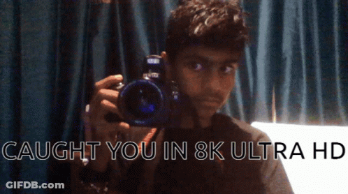 A Man Holding A Camera With The Words Caught You In 8K Ultra Hd On The Bottom GIF