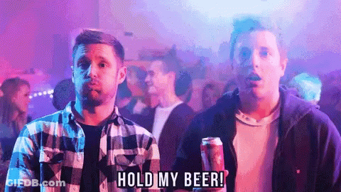 A Man Holding A Can Of Beer With The Words Hold My Beer Below Him GIF