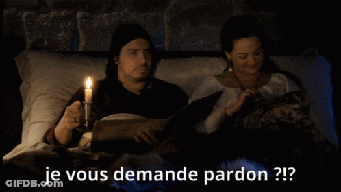 A Man Holding A Candle Next To A Woman Who Is Reading A Book With The Words Je Vous Demande Pardon Written Below Them GIF
