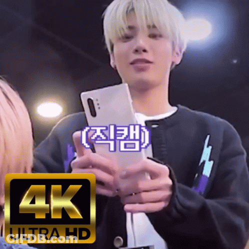 A Man Holding A Cell Phone With A 4K Ultra Hd Logo In The Corner GIF