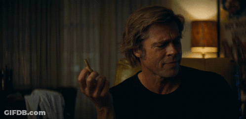 A Man Holding A Cigarette In Front Of A Sign That Says " Why Not " GIF