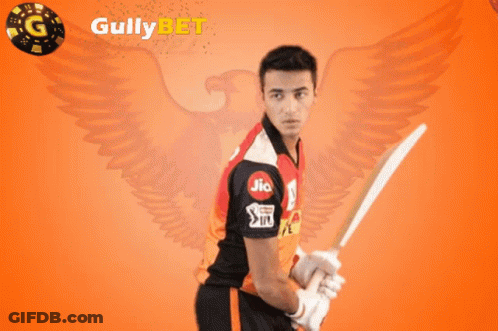 A Man Holding A Cricket Bat In Front Of A Gully Bet Logo GIF