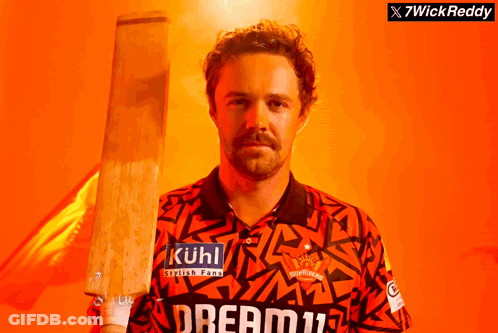 A Man Holding A Cricket Bat With Kuhl Written On His Shirt GIF