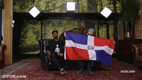 A Man Holding A Dominican Flag Next To A Bear GIF