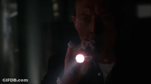 A Man Holding A Flashlight In The Dark GIF
