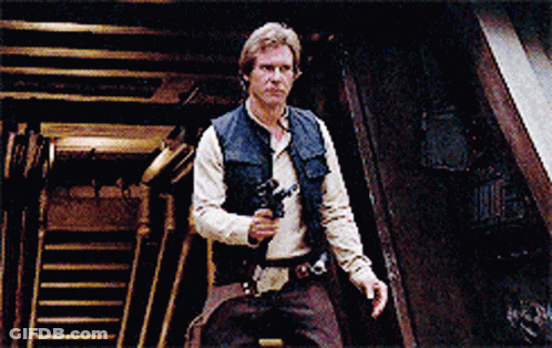 A Man Holding A Gun In A Dark Room With Stairs In The Background GIF