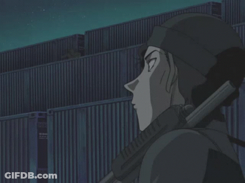 A Man Holding A Gun In Front Of A Building At Night GIF