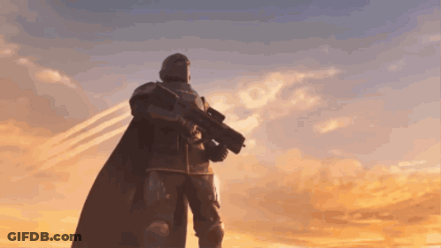 A Man Holding A Gun In Front Of A Sunset GIF