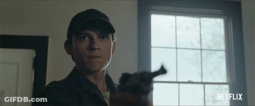 A Man Holding A Gun In Front Of A Window With Netflix Written On The Bottom Right GIF