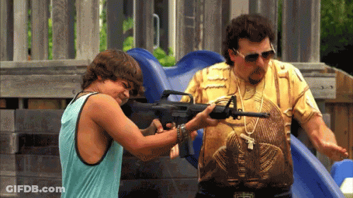 A Man Holding A Gun Next To A Boy Wearing A Shirt That Says Egyptian GIF