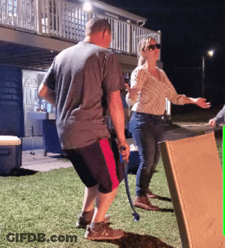Man Holding Hose Next To Woman And Box GIF