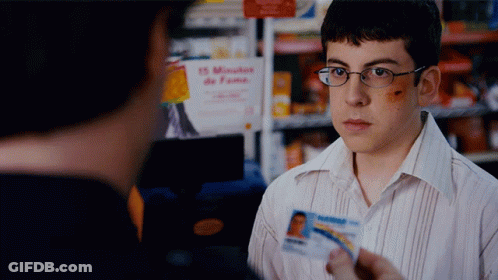 A Man Holding A Id Card In Front Of A Sign That Says 15 Minutes GIF