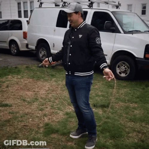 A Man Holding A Jump Rope In Front Of A White Van With The Number 8 On It GIF