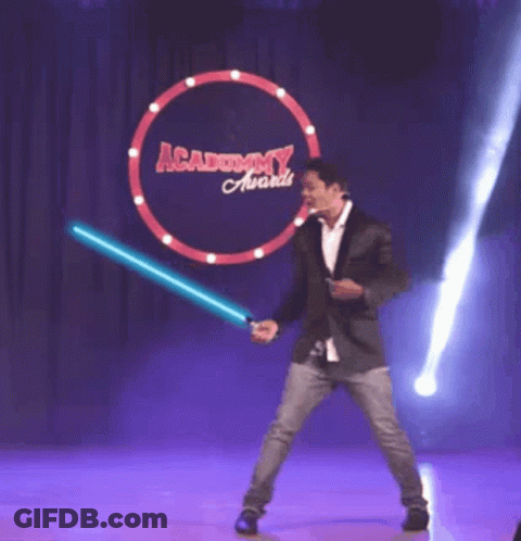 A Man Holding A Light Saber In Front Of An Academy Award Sign GIF