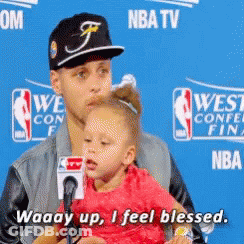 A Man Holding A Little Girl In Front Of A Nba Tv Sign GIF