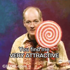 A Man Holding A Lollipop With The Words You Find Me Very Attractive Below Him GIF