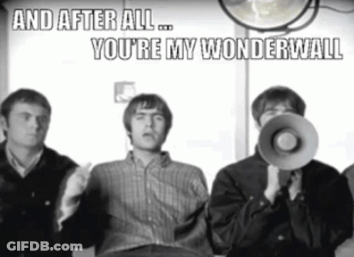 A Man Holding A Megaphone With The Words And After All You 'Re My Wonderwall Above Him GIF