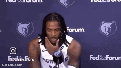 A Man Holding A Microphone In Front Of A Fedex Forum Logo GIF