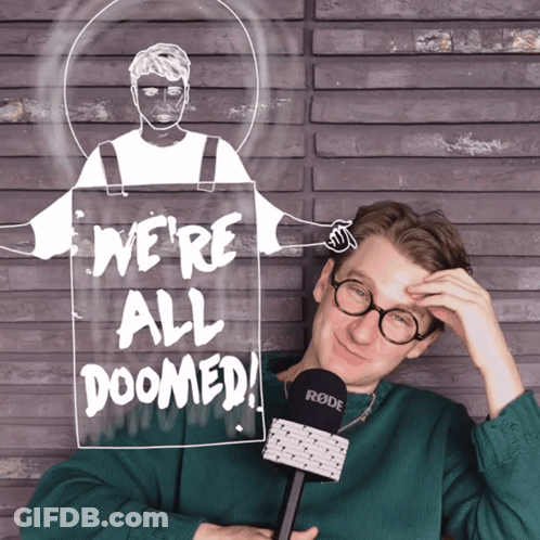 A Man Holding A Microphone In Front Of A Sign Saying We 'Re All Doomed GIF