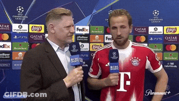 A Man Holding A Microphone Next To A Man In A T-Mobile Shirt GIF