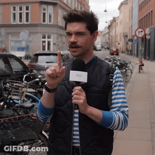 A Man Holding A Microphone With The Letter Mh On It GIF