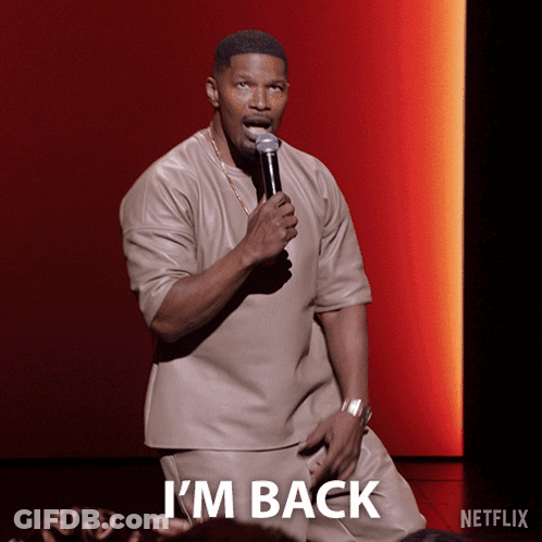 A Man Holding A Microphone With The Word I 'M Back On The Bottom GIF