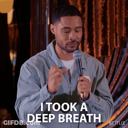 A Man Holding A Microphone With The Words I Took A Deep Breath Below Him GIF