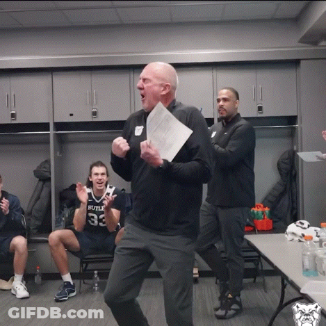 A Man Holding A Piece Of Paper In Front Of A Man Wearing A Bulls Jersey GIF